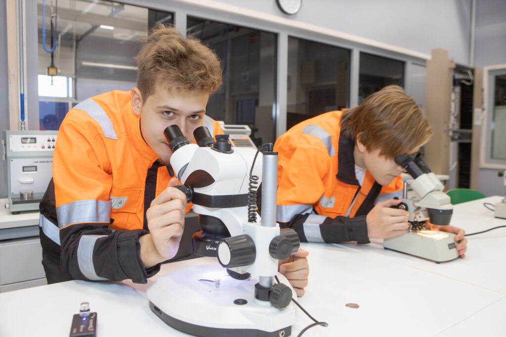 Kaksi prosessialan opiskelijaa käyttämässä mikroskooppeja.