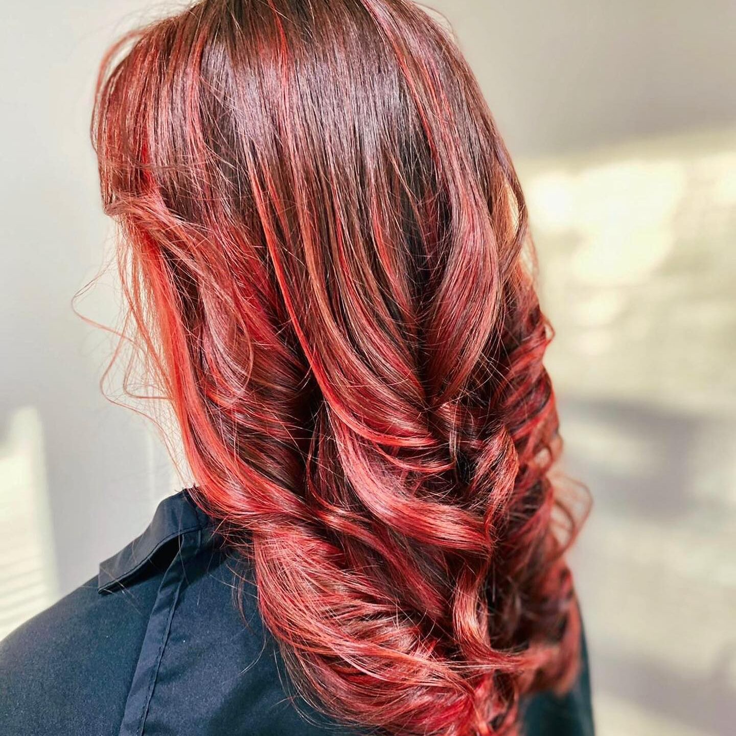 Punaiset, kiharretut hiukset kuvattuna takaapäin.